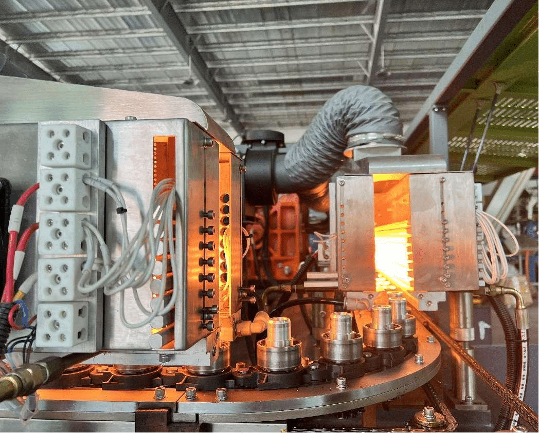 A Bottle Blowing Machine With A Noticeably Long Heating Oven Section.
