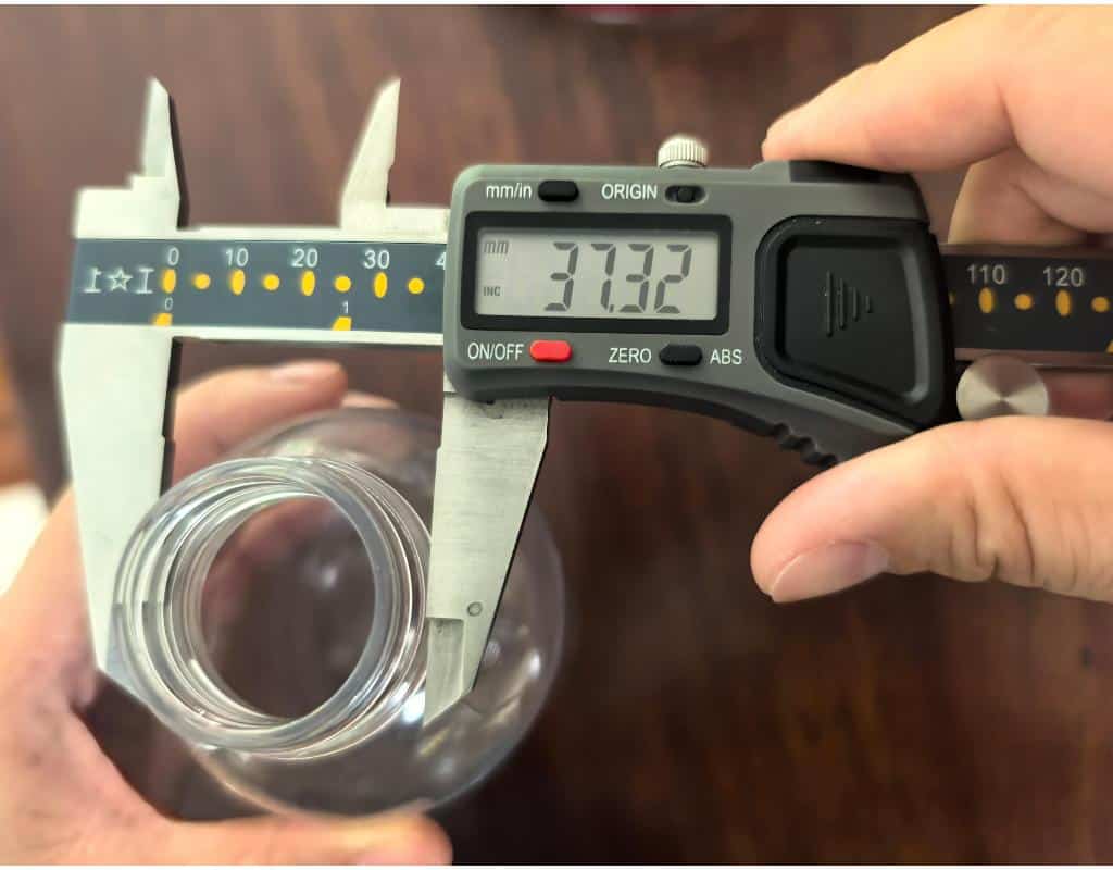 An Operator Inspecting A Bottle Neck For Ovality