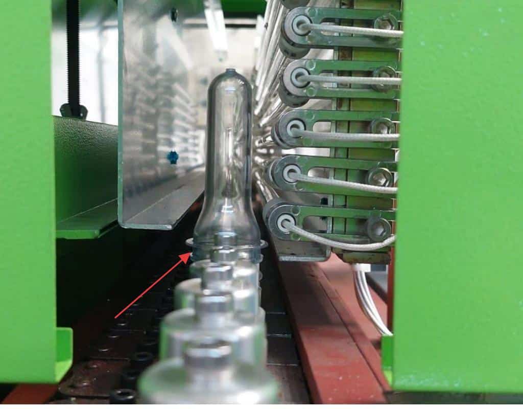 A Technician Adjusting A Neck Shield In A Blow Molding Machine