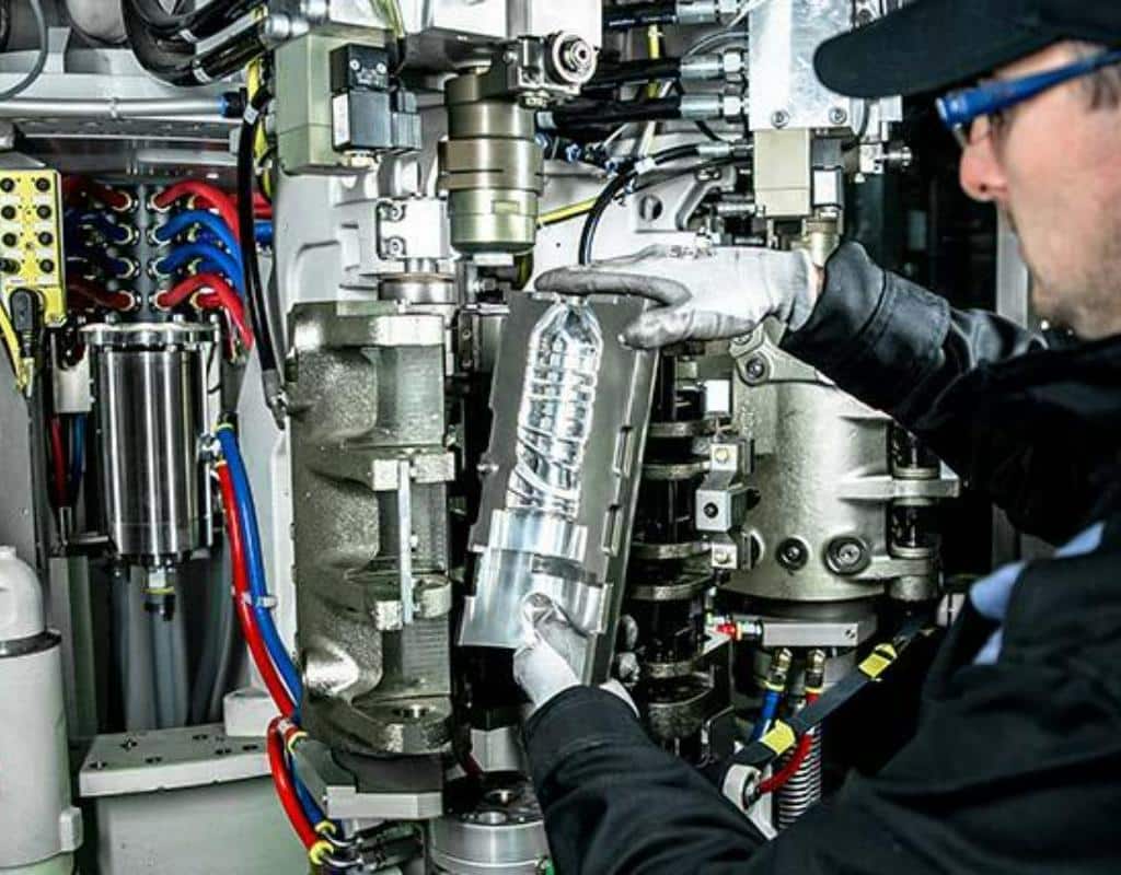 A Technician Easily Installing A New Mold Into A Blow Molding Machine